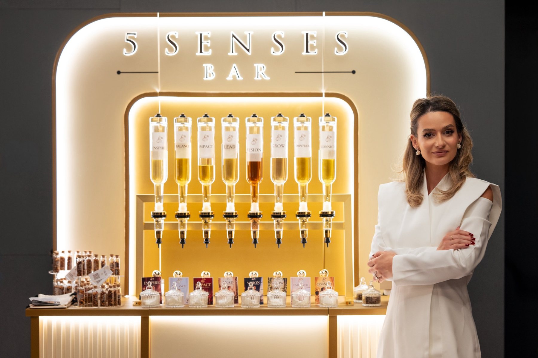 Barul 5 Senses Bar cu dozatoare de arome, iar Beatrice stă în dreapta lui