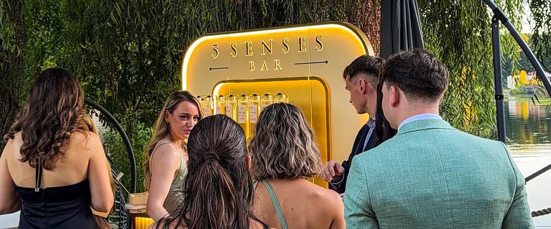 Invitați adunați în jurul standului 5 Senses Bar, la un eveniment în aer liber