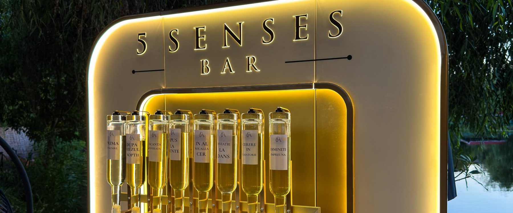 Semnul luminat 5 Senses Bar și sticlele de parfum, văzute de aproape